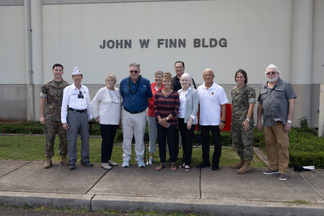 Jim Brueckner, great nephew of Medal of Honor recipient U.S. Navy Chief Petty Officer John W. Finn, poses for a photo with family, friends, and Marines in front of the John W. Finn Building during a visit to Marine Corps Base Hawaii, Feb. 27, 2023. The visit provided a visual and historic understanding of the attacks that occurred on Naval Air Station Kaneohe Bay on Dec. 7, 1941, in which Finn’s acts of heroism earned him the Congressional Medal of Honor. (U.S. Marine Corps photo by Cpl. Chandler Stacy)