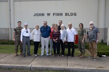Jim Brueckner, great nephew of Medal of Honor recipient U.S. Navy Chief Petty Officer John W. Finn, poses for a photo with family, friends, and Marines in front of the John W. Finn Building during a visit to Marine Corps Base Hawaii, Feb. 27, 2023. The visit provided a visual and historic understanding of the attacks that occurred on Naval Air Station Kaneohe Bay on Dec. 7, 1941, in which Finn’s acts of heroism earned him the Congressional Medal of Honor. (U.S. Marine Corps photo by Cpl. Chandler Stacy)
