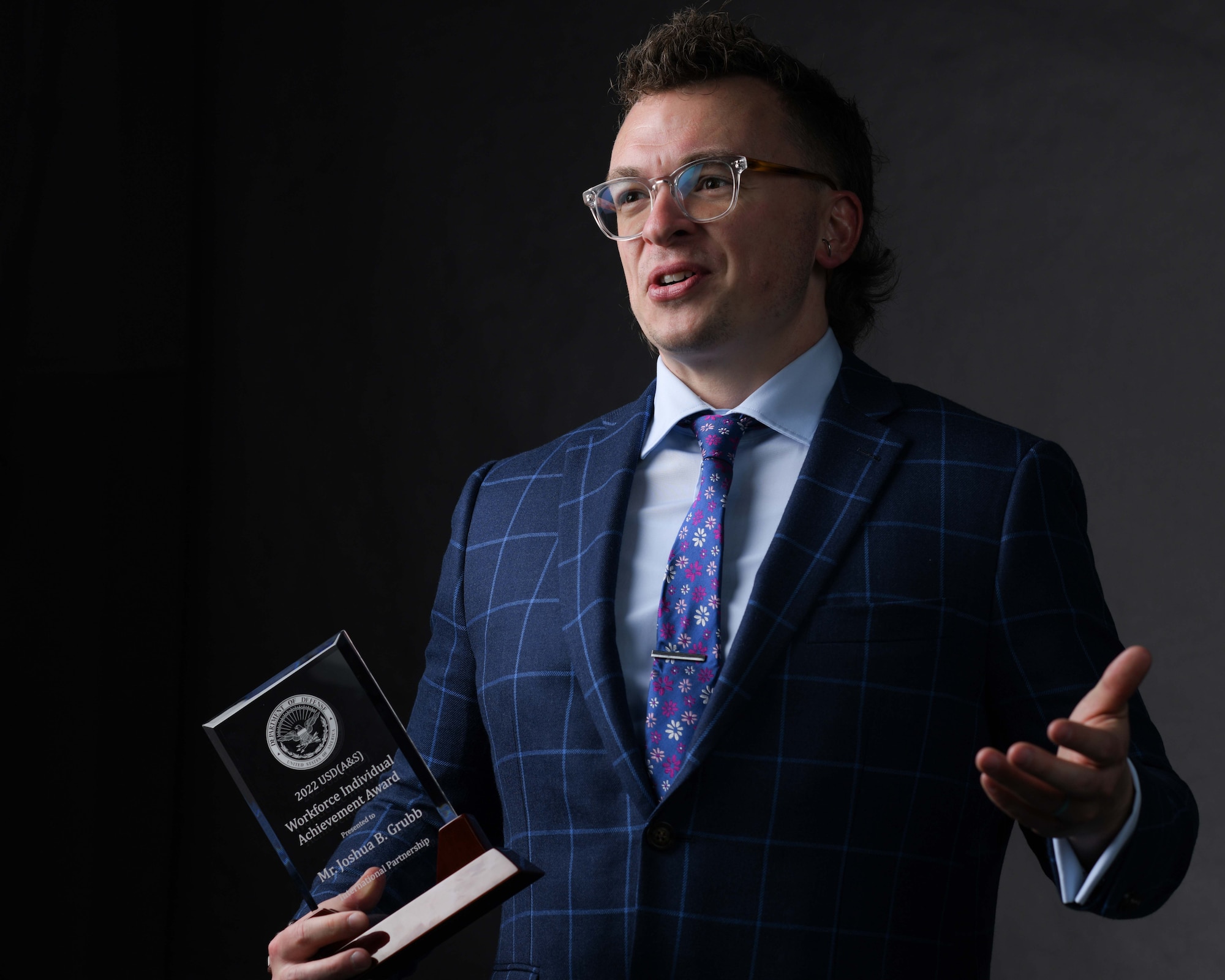 A contracting director stands with his award