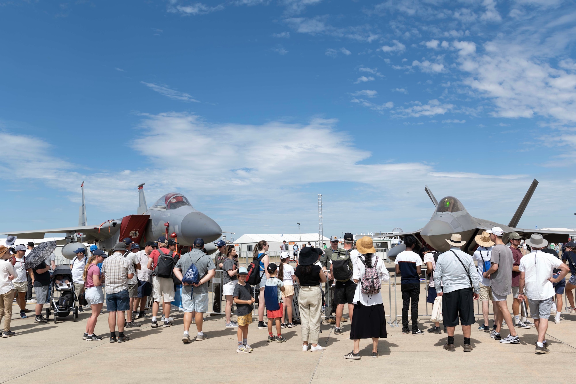 People gather around two fighter jets