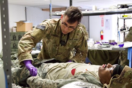 A U.S. Soldier provides aid to a simulated casualty at a field hospital during an exercise at Fort Indiantown Gap, March 3, 2023. This exercise included responding to the scene of a mass casualty event, providing first aid and evacuating the simulated casualties to a field hospital where they received further care, all while being assessed by instructors with the Pennsylvania National Guard’s 4th Battalion, 166th Regiment Regional Training Institute (Medical Battalion Training Site). (U.S. Army National Guard photo by Maj. Travis Mueller)