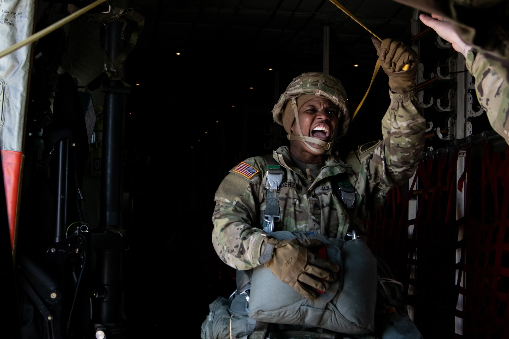 A photo of a paratrooper yelling as the move to exit an aircraft