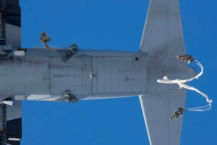 A photo of paratroopers leaping from an aircraft