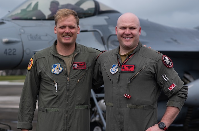 1st Lt. Matthew "Shoots" Oliver, 13th Fighter Squadron, Misawa Air base, Japan, F-16 Fighting Falcon pilot, front seat, and Maj. Michael "Deuce" Oliver, 3rd Wing, Joint Base Elmendorf-Richardson, Alaska, F-22 pilot, back seat, prepare to fly in a F-16D model aircraft at Andersen Air Force Base, Guam. (Courtesy Photo)