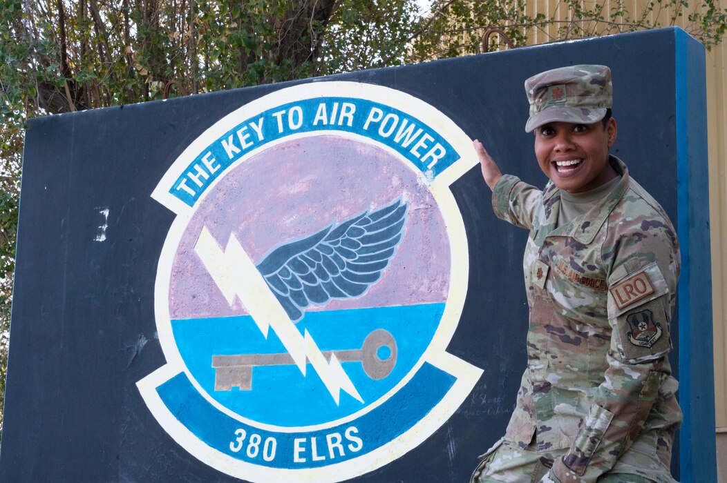 U.S. Air Force Maj. Katia Pillot, 380th Expeditionary Logistics Readiness Squadron director of operations, poses with the 380 ELRS t-wall mural, Feb. 20, 2023. Pillot won the Logistics Field Grade Officer of the Year at the Air Forces Central Command and Air Combat Command for her work in 2022. (U.S. Air Force photo by 1st Lt. Alexandra Smith)