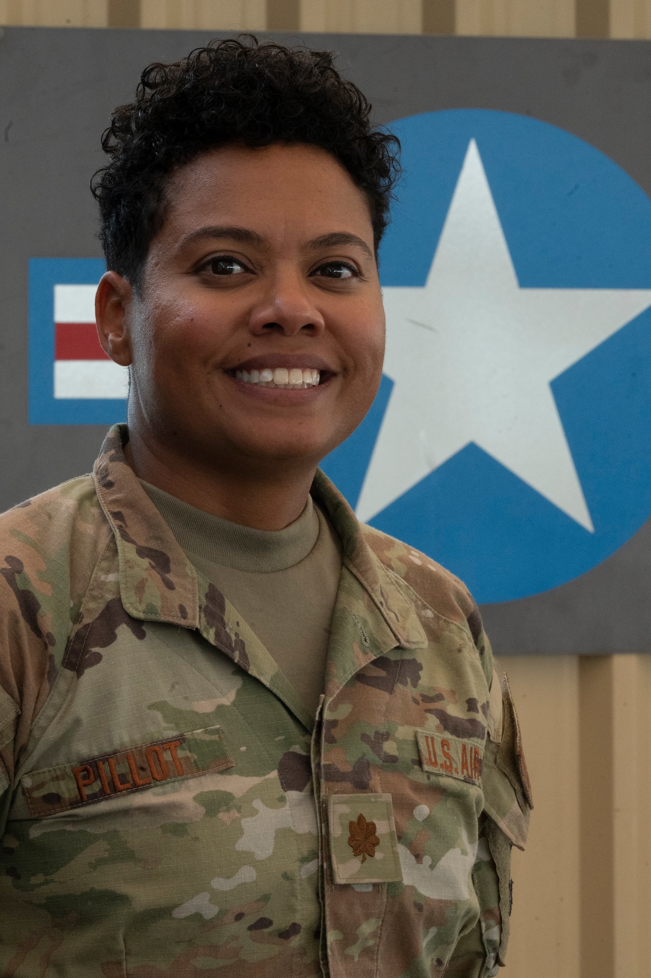 Maj. Katia Pillot, 380th Expeditionary Logistics Readiness Squadron director of operations, poses in front of a U.S. Air Force roundel at Al Dhafra Air Base, United Arab Emirates, Feb. 20, 2023. Pillot spoke about her Air Force experience as a prior enlisted officer, a female minority leader, and the key to her success in her career thus far. (U.S. Air Force photo by 1st Lt. Alexandra Smith)
