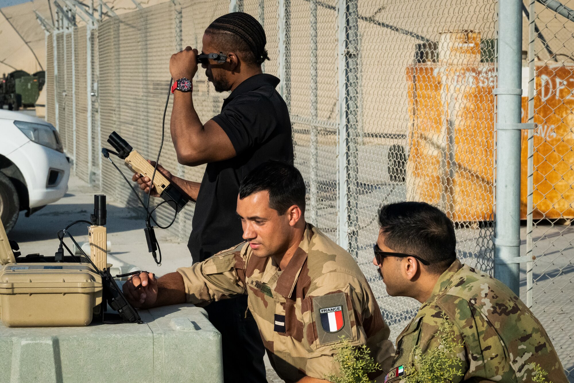 Dan Joseph (left), L-3 Harris contractor, French Army Master Sgt. Nicolas Eon (center), Battalion 5 CAV Regiment, Joint Terminal Attack Controller (JTAC), and U.S. Air Force Capt. Maheep Gill, 62nd Expeditionary Attack Squadron MQ-9 Reaper pilot, watch a live feed from a U.S. Air Force MQ-9 Reaper through a Tactical Network Receiver (TNR) at Al Dhafra Air Base, United Arab Emirates, March 7, 2023. Use of the TNR allow JTACs the ability to see what the unmanned aerial vehicle is seeing to help coordinate ground tactics in real time. (U.S. Air Force photo by Staff Sgt. Sabatino DiMascio)