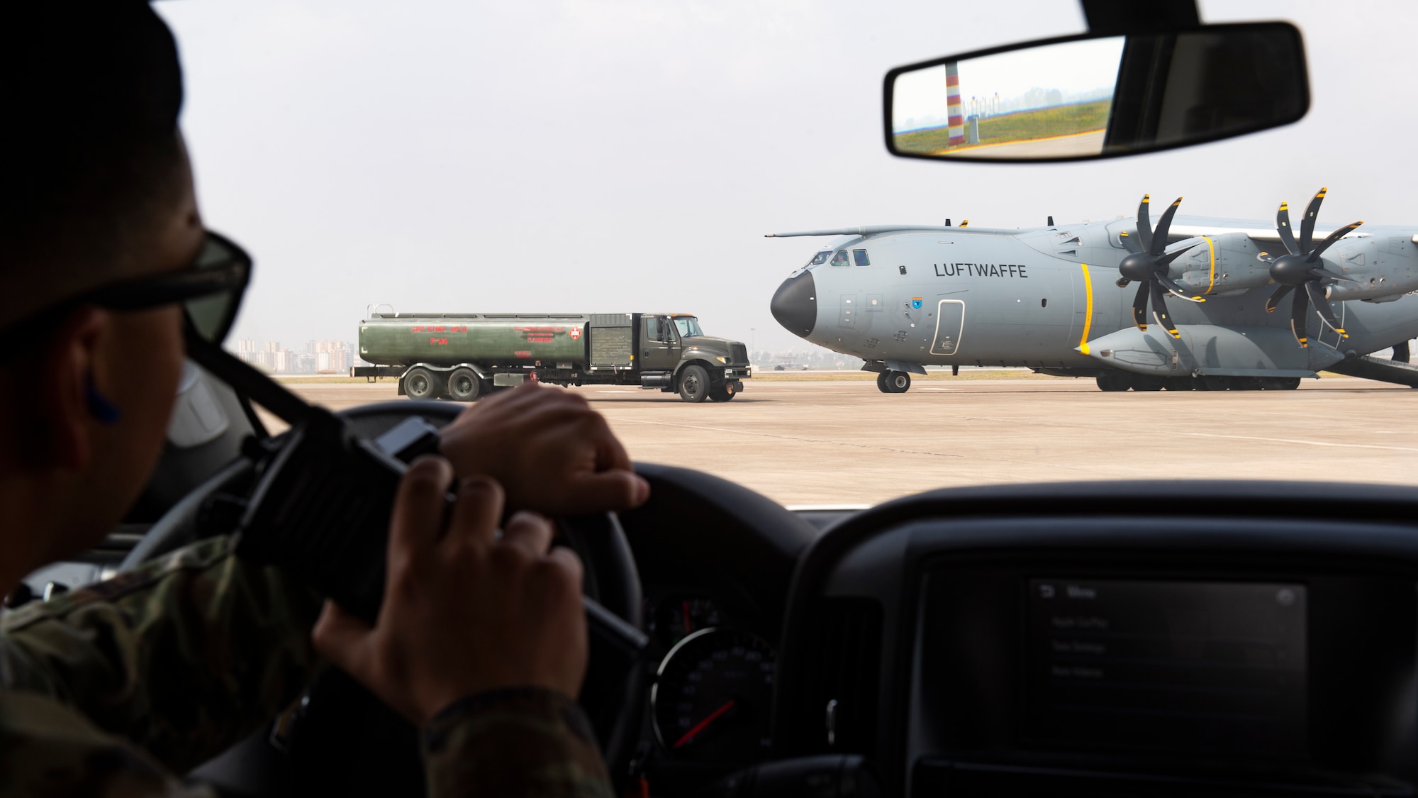 U.S. Air Force Staff Sgt. Ryan Vasquez, a fuels equipment maintenance supervisor assigned to the 39th Logistics Readiness Squadron, coordinates an R-11 fuel truck movement near a German Air Force A400M Atlas military transport aircraft in support of Turkish government earthquake relief operations March 3, 2023, at Incirlik Air Base, Türkiye. U.S. military organizations are working with interagency colleagues to harness the unique capabilities available to assist those affected by the earthquakes. The U.S. military’s role during these relief missions is to rapidly respond to this natural disaster with critical support capabilities and life-saving equipment, transporting assistance for aid areas the government of Türkiye deems most necessary. (U.S. Air Force photo by Staff Sgt. Peter Reft)