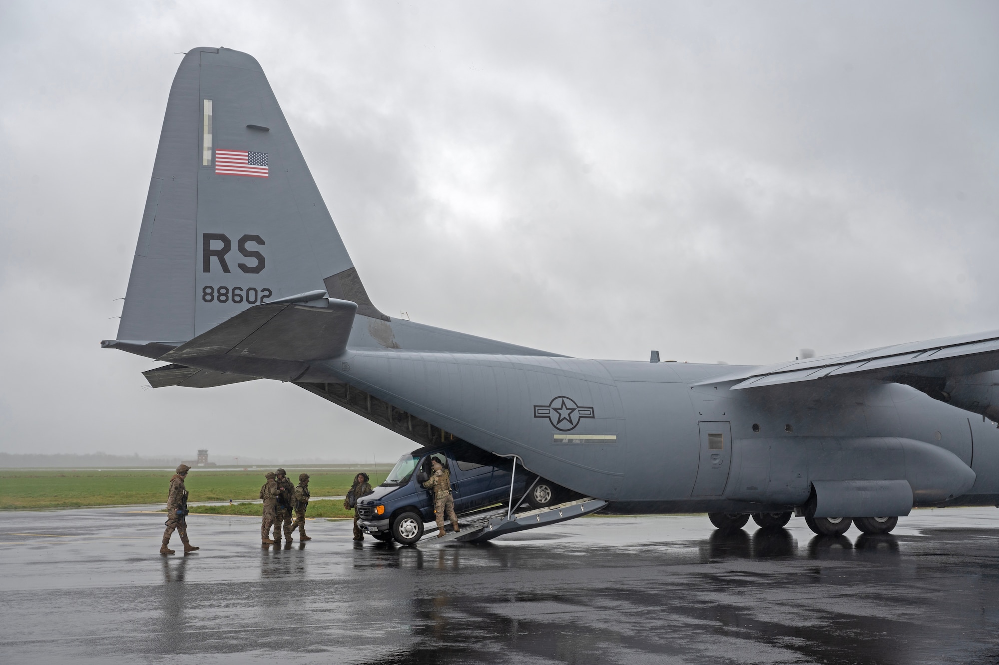 Members from the 435th Contingency Response Squadron guide a government vehicle into a C-130J Super Hercules cargo aircraft during an engine running onload procedure at Chièvres Air Base, Belgium during Exercise Agile Bison, March 9, 2023.