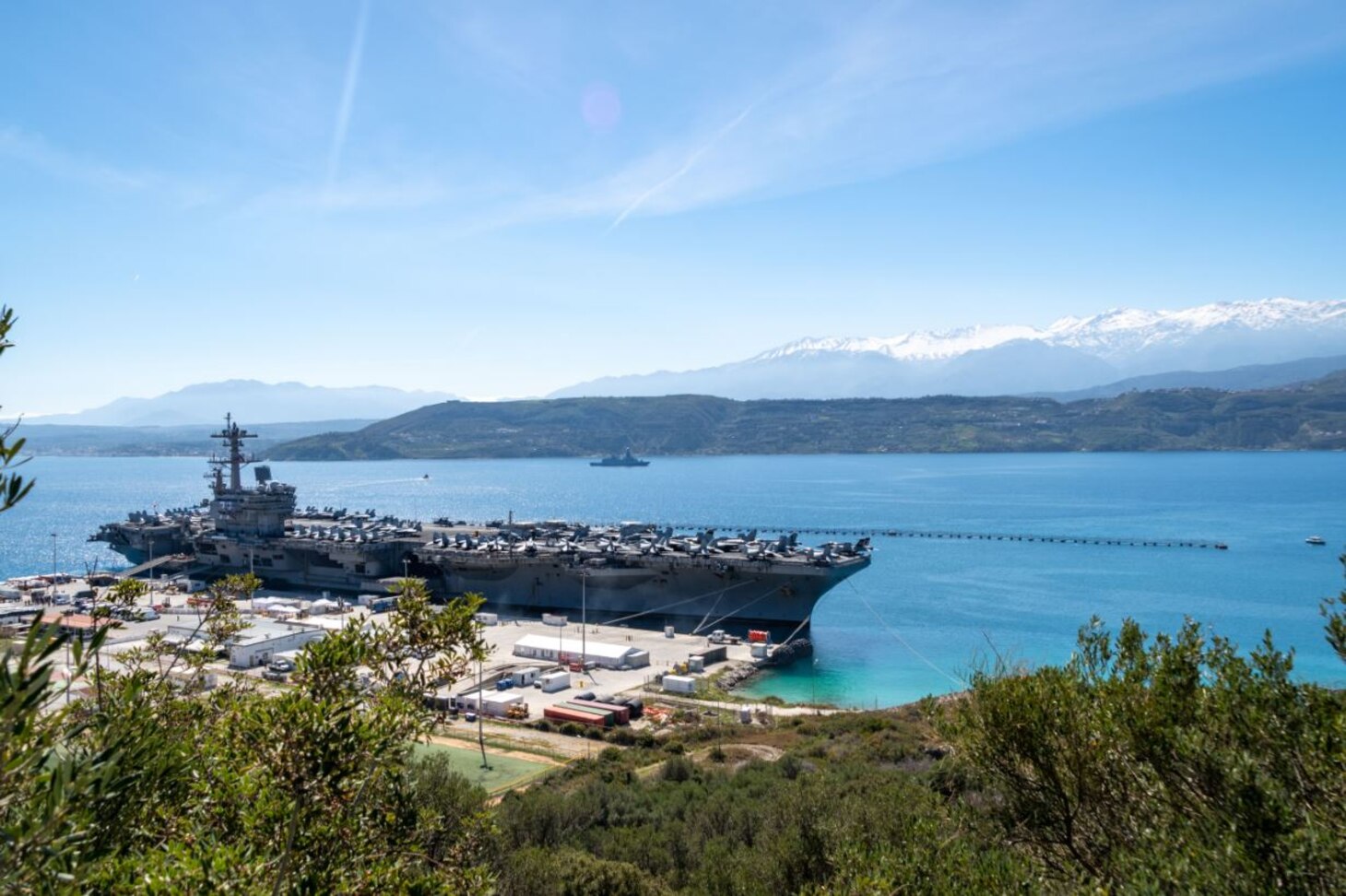 (March 10, 2023) The Nimitz-class aircraft carrier USS George H.W. Bush (CVN 77), along with the embarked staff of Carrier Strike Group 10, arrives in Souda Bay, Crete for a scheduled port visit, March 10, 2023. The George H.W. Bush Carrier Strike Group is on a scheduled deployment in the U.S. Naval Forces Europe area of operations, employed by U.S. Sixth Fleet, to defend U.S., allied, and partner interests. NSA Souda Bay is an operational ashore installation which enables and supports U.S., Allied, Coalition, and Partner nation forces to preserve security and stability in the European, African, and Central Command areas of responsibility.