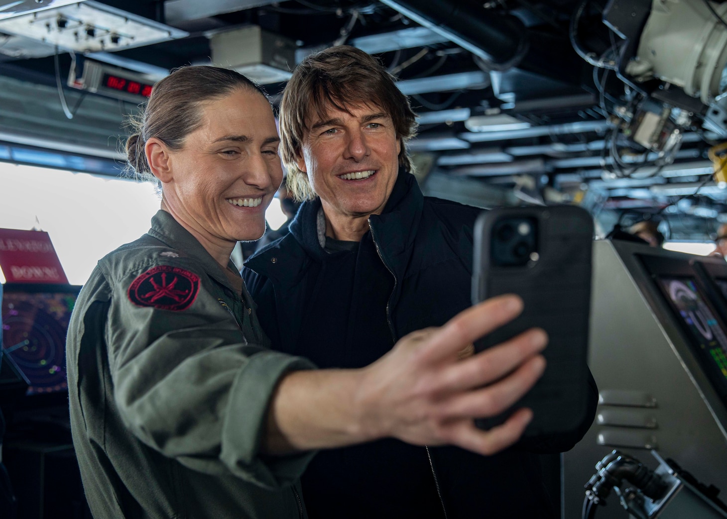 (March 3, 2023) Cmdr. Karrie Lang, Combat Systems Officer aboard the Nimitz-class aircraft carrier USS George H. W. Bush (CVN 77), takes a selfie with Tom Cruise during a visit to the ship, March 3, 2023. The George H.W. Bush Carrier Strike Group is on a scheduled deployment in the U.S. Naval Forces Europe area of operations, employed by U.S. Sixth Fleet to defend U.S., allied and partner interests.