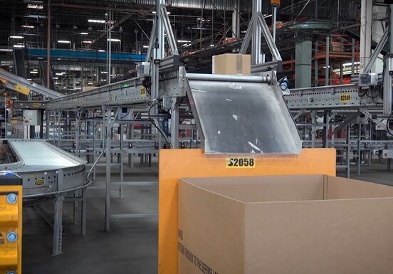Photo of packages moving through a large warehouse on multiple level conveyor belts.