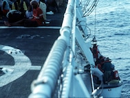 Haitian refugees sit on the flight deck of the USCGC Dauntless while more are brought aboard.