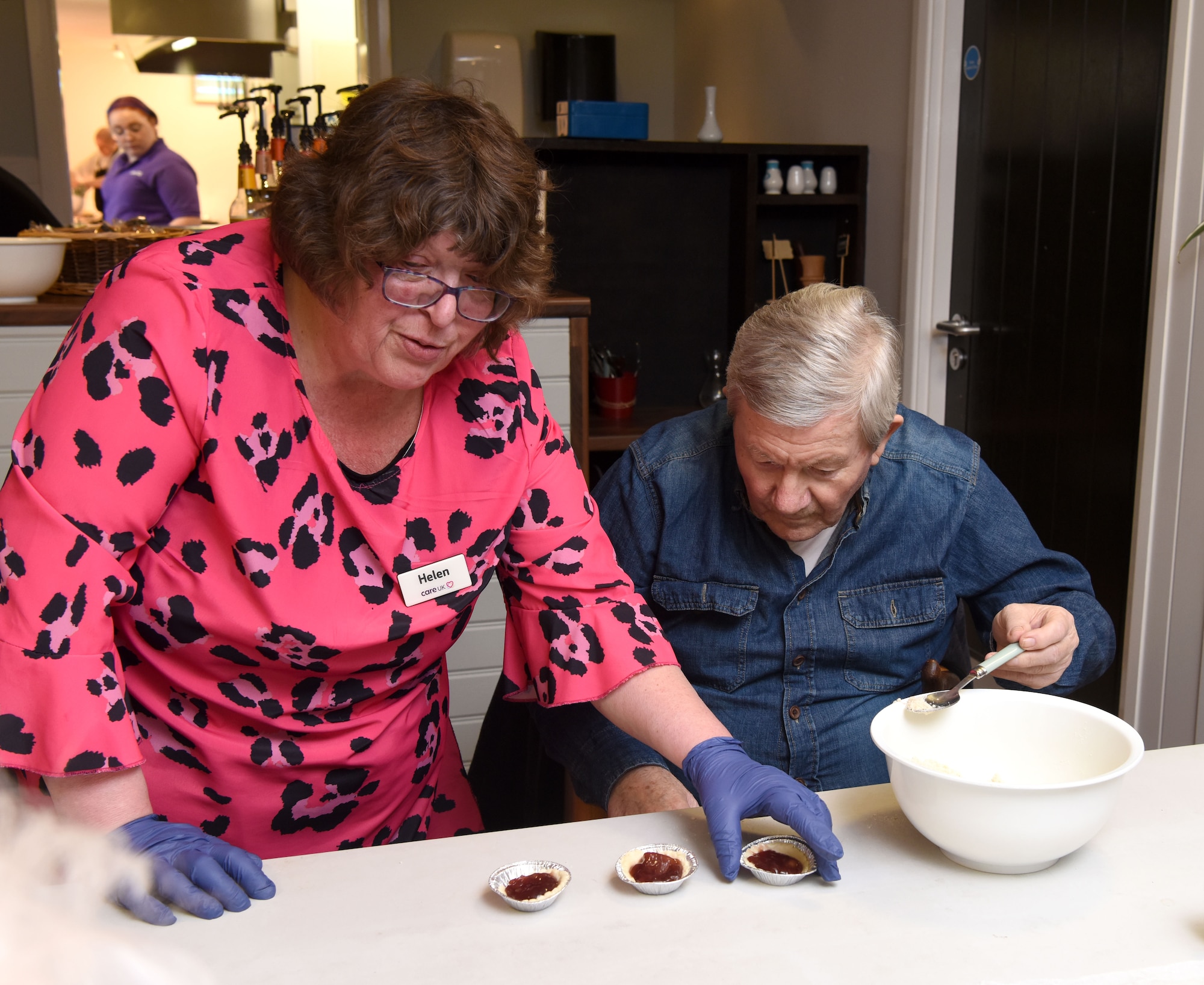 Helen Butcher, left, Mildenhall Lodge Care Home lifestyle coordinator, and Richard, a care home resident, make apple and blackberry pies at Mildenhall Lodge Care Home, Mildenhall, England, March 9, 2023. Team Mildenhall Airmen volunteered at the care home, tidying the garden, planting spring flowers and baking with the residents. (U.S. Air Force photo by Karen Abeyasekere)