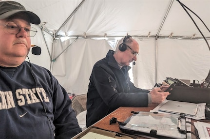 IMAGE: Naval Surface Warfare Center Dahlgren Division (NSWCDD) lead systems engineer Scott Larimer (left) works at the “net control” station during the 2022 Marine Corps Marathon. Larimer volunteers his amateur radio skills to about 40 area events each year. Larimer received the NSWCDD Distinguished Community Service Award for his dedication to community service on March 10 at the NSWCDD Honorary Awards Ceremony.