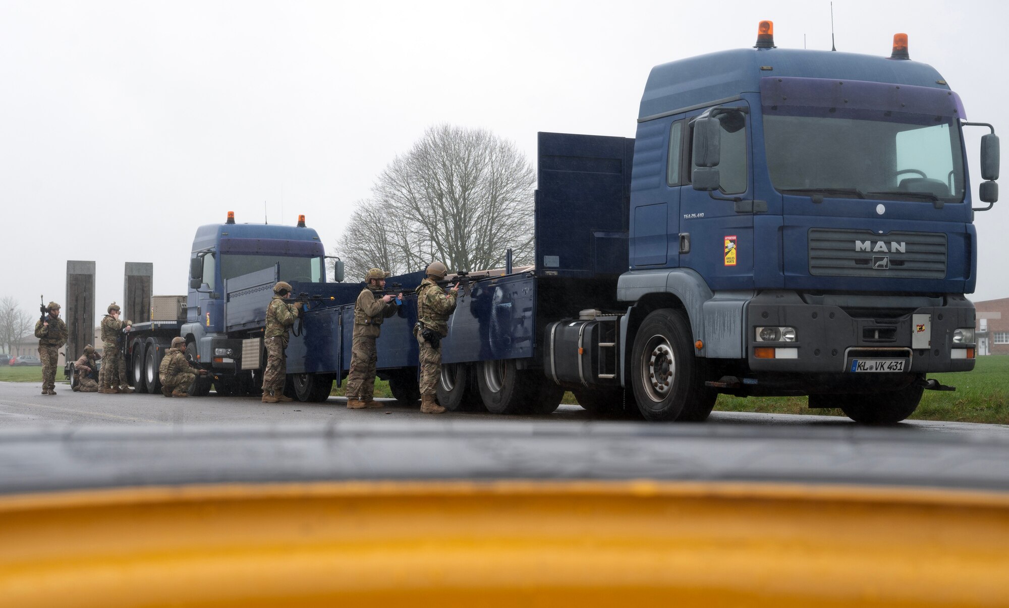 U.S. Air Force Airmen line up against a truck to return fire