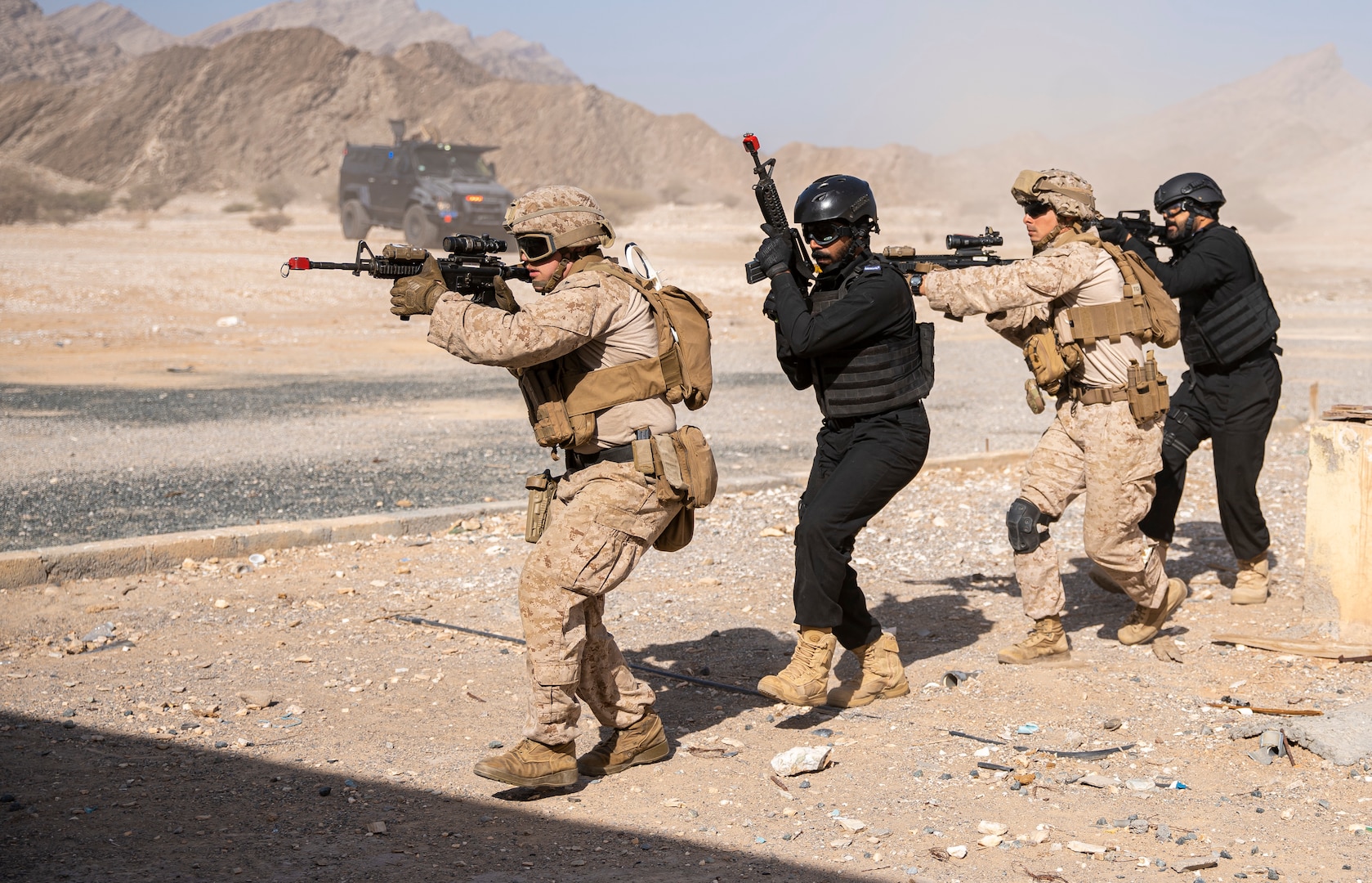 OMAN (February 23, 2023) – U.S. Marines assigned to Fleet Anti-Terrorism Security Team Central Command (FASTCENT) and members of the Royal Oman Police Special Task unit  approach their objective building during the final demonstration in exercise Invincible Sentry 23 in Oman Feb. 23. IS23 is a recurring exercise held with different partner nations each year within U.S. Central Command’s area of responsibility to evaluate the readiness and capabilities of U.S. and Omani forces responding to a regional emergency. (U.S. Marine Corps photo by Staff Sgt. Benjamin McDonald)