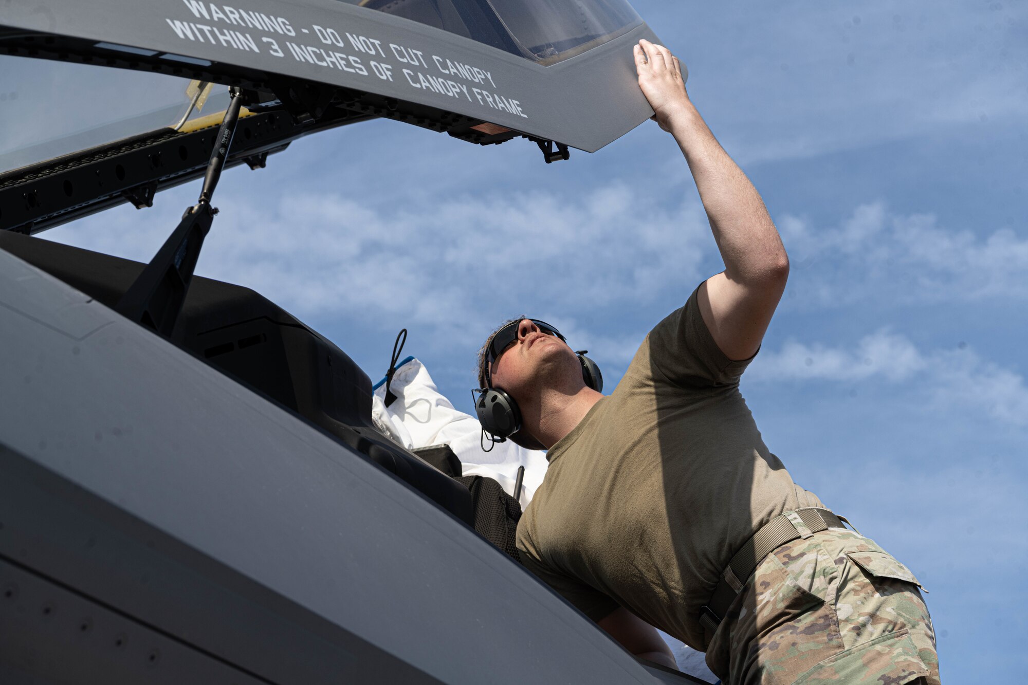 a photo of an F-35 maintainer performing an inspection