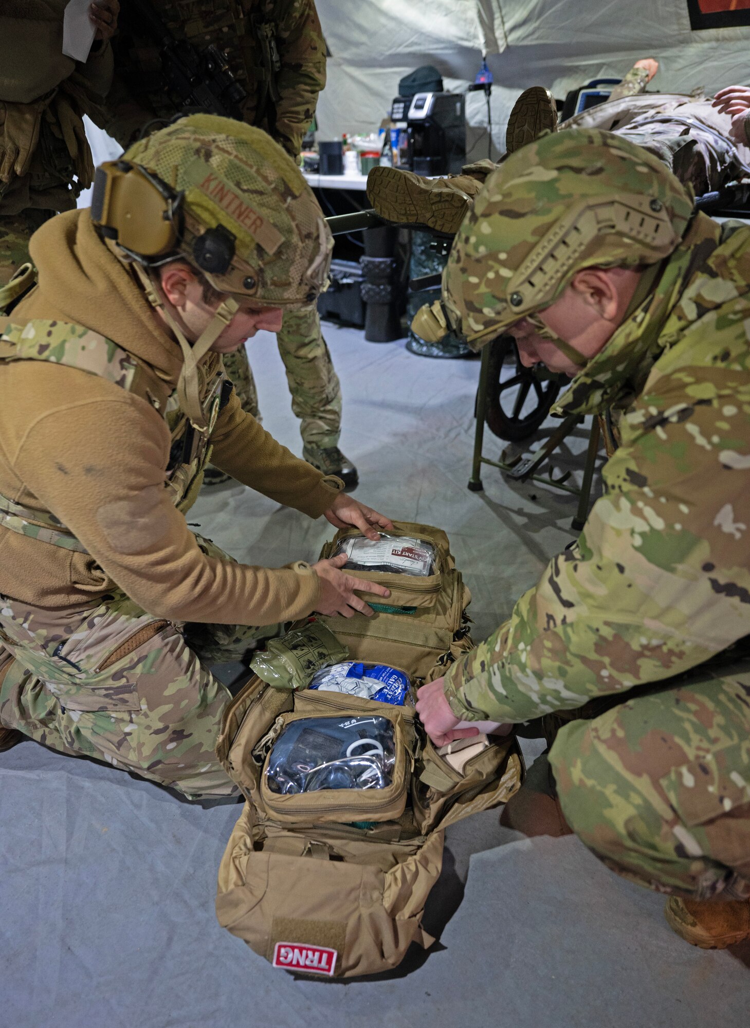 U.S. Staff Sgt. Trevor Kintner, left, 435th Contingency Response Squadron network communications journeyman, and Senior Airman Freddyjames Atwood, right, 435th Contingency Response Squadron aircraft mechanic, retrieve medical supplies for an emergency involving two simulated patients during Exercise Agile Bison at Chièvres Air Base, Belgium, March 10, 2023.