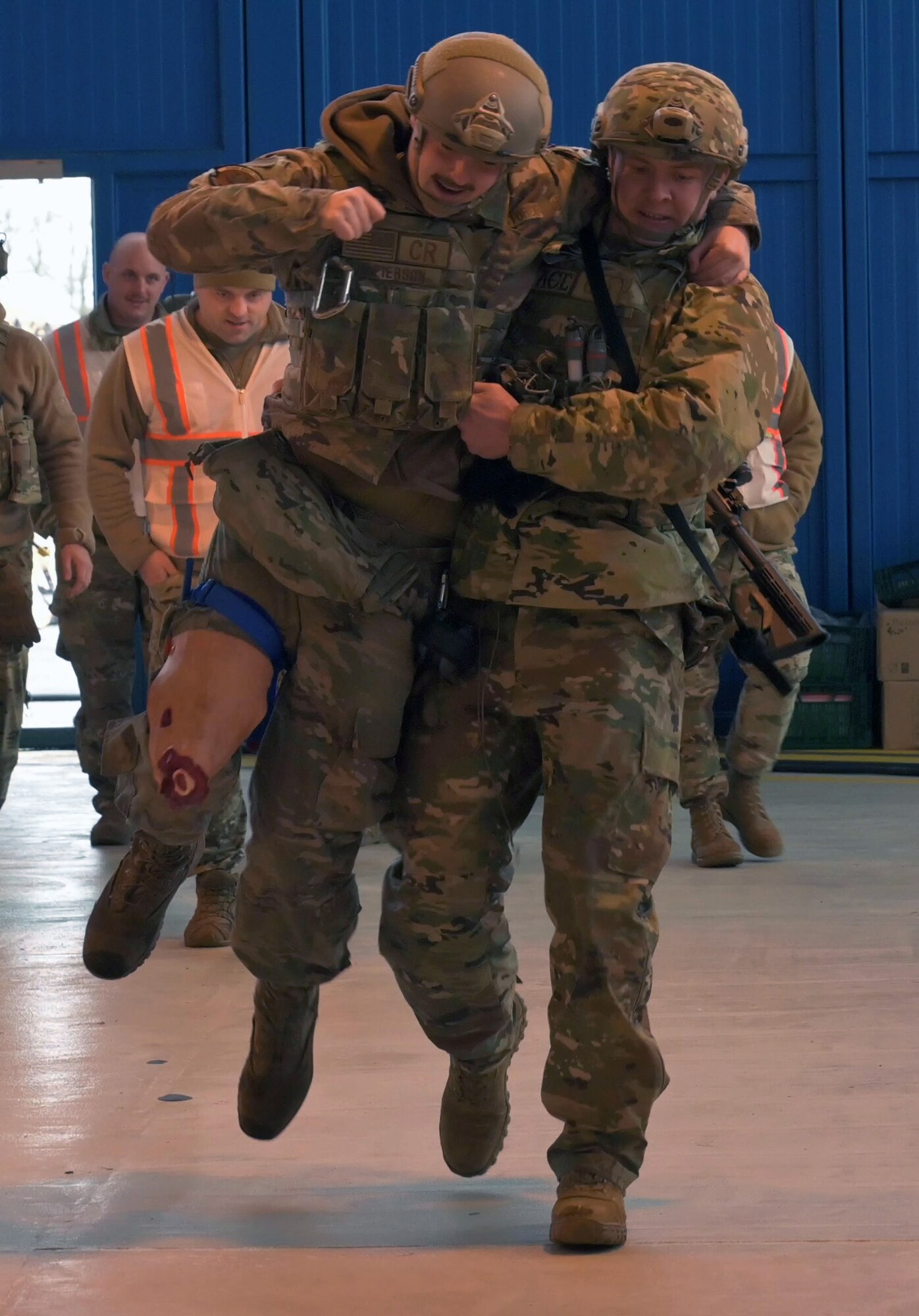 U.S. Air Force Senior Airman Andrew Pierson, left, 435th Contingency Response Squadron mobile aerial port journeyman, is being transported by Senior Airman Freddyjames Atwood, right, 435th Contingency Response Squadron aircraft mechanic, to the medical tent during a scenario-based accident as part of Exercise Agile Bison at Chièvres Air Base, Belgium, March 10, 2023.