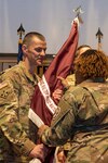 Command Sgt. Maj. Scott Pierce, assigned to Walter Reed National Military Medical Center (WRNMMC) Troop Command, receives the unit's colors from Col. Sabrina Thweatt, commander of WRNMMC Troop Command, during a change of responsibility ceremony in Clark Auditorium at WRNMMC in Bethesda, Maryland, Mar. 10, 2023. Pierce relieved Command Sgt. Maj. Chanda McGinnis from her role as command sergeant major for WRNMMC Troop Command.