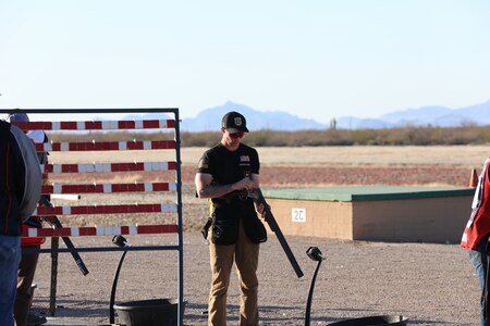 Man inspects his shotgun during a match in Tucson, Arizona