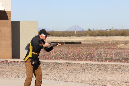 Man inspects his shotgun during match in Tucson, Arizona