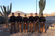 Shotgun team poses for a group photo in front of cactus in Tucson, Arizona