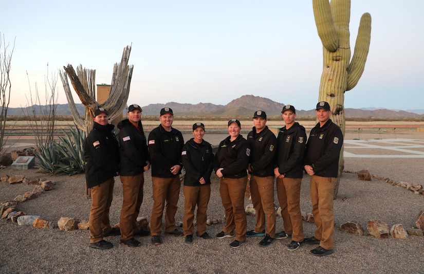 Shotgun team poses for a group photo in front of cactus in Tucson, Arizona