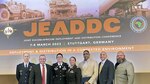 Seven DLA Europe & Africa Team members standing in front of Joint European Command and Africa Command conference sign.