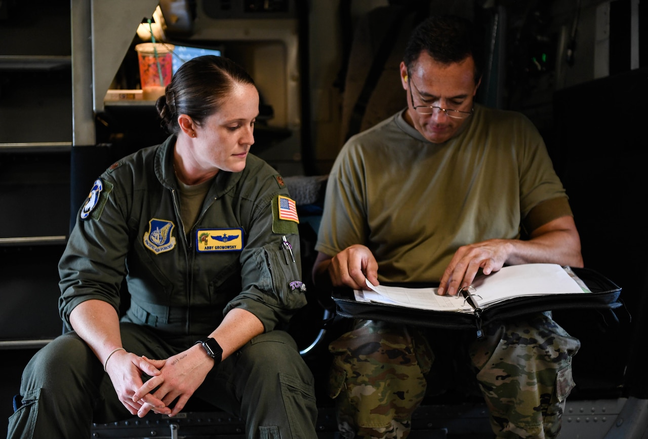 Two airmen review aircraft forms.