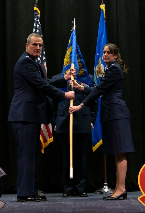 U.S. Air Force Col. Joe Marcinek, 655th Intelligence, Surveillance, and Reconnaissance Wing commander, and Col. Jennifer Mulder, 655 ISR Group commander, hold the guidon during the 655 ISRG change of command ceremony March 4, 2023, at the National Museum of the Air Force at Wright-Patterson Air Force Base, Ohio. The 655 ISRG change of command ceremony honored both the outgoing commander, Mulder, and the incoming commander, Bernkopf.