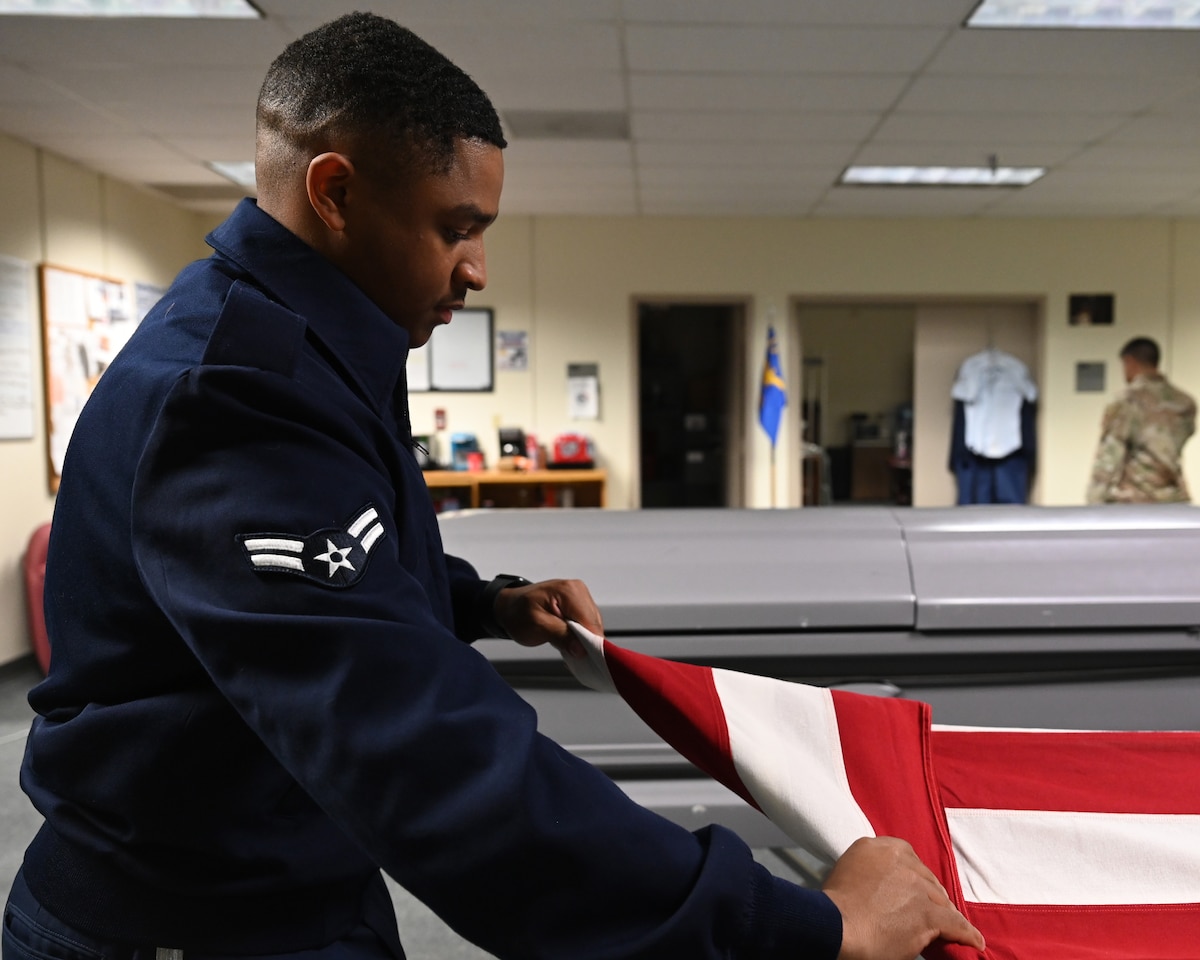 U.S. Air Force Airman 1st Class Joshua Knight, 17th Training Wing base Honor Guard member, folds a flag during a practice for an Honor Guard detail, Goodfellow Air Force Base, Texas, Mar. 8, 2023. When folding a flag to pass on to the next of kin or associate of the deceased, movements must be precise to ensure no red or white stripes show after the final fold. (U.S. Air Force photo by Airman 1st Class Zachary Heimbuch)