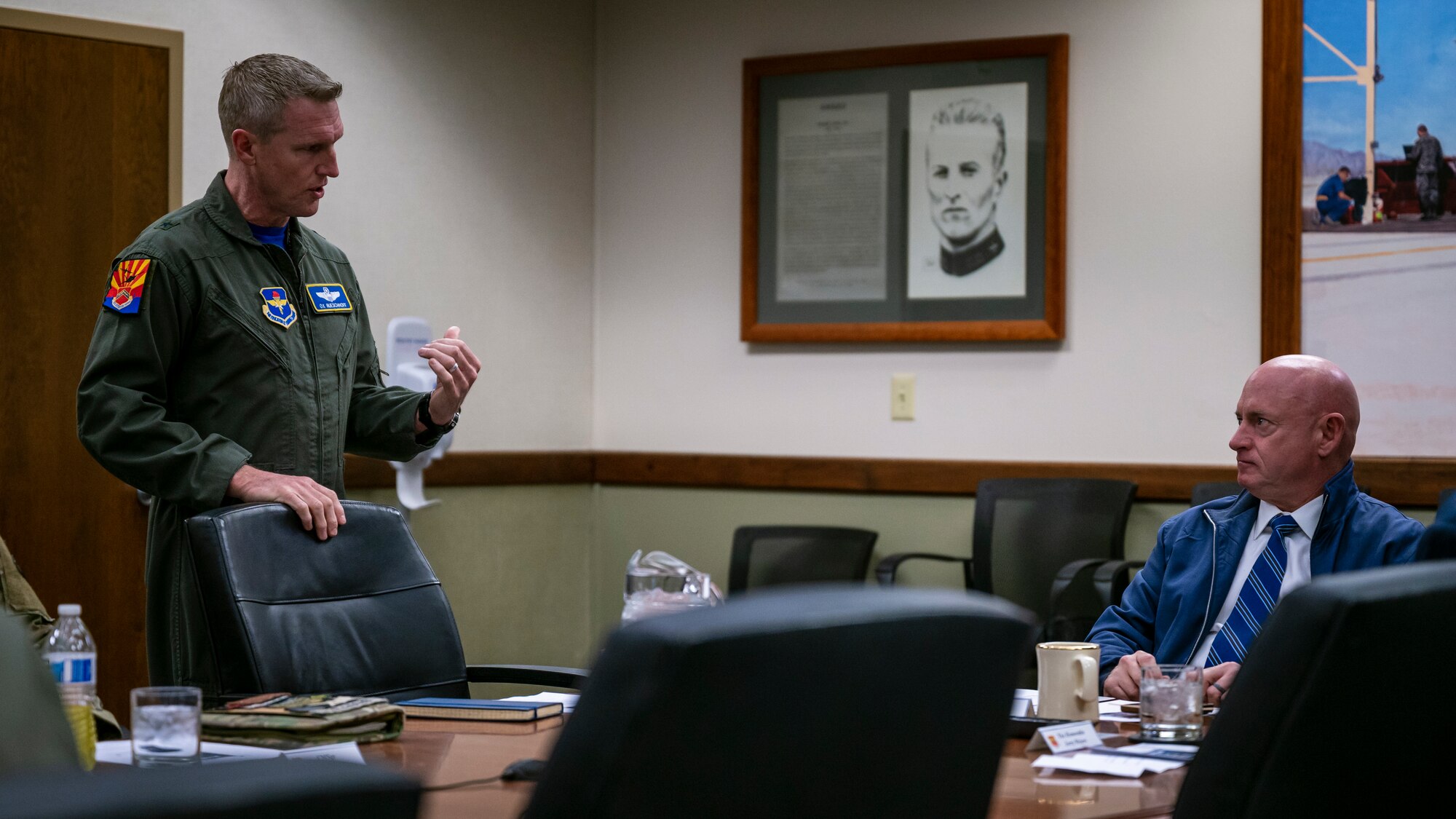 U.S. Air Force Brig. Gen. Jason M. Rueschhoff (left), 56th Fighter Wing commander, addresses U.S. Senator Mark Kelly (right), March 10, 2023, at Luke Air Force Base, Arizona.