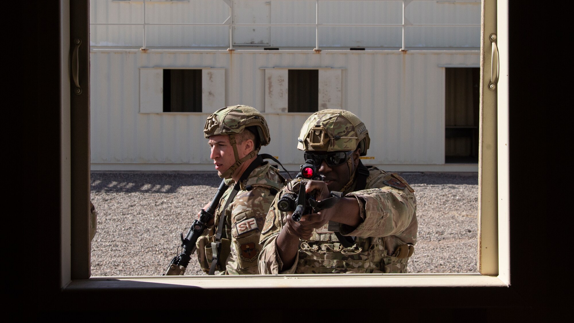 U.S. Air Force Senior Airman Aaron Fulmore,center, 49th Security Forces Squadron base defense operations center controller, clears a window in an urban operations exercise during the first-ever-ever Fire Team Leaders Course at Holloman Air Force Base, New Mexico, Feb. 28, 2023. The course placed heavy emphasis on small-arms marksmanship fundamentals, mission planning, operations in urban environments, small unit tactics, and the overall ability to shoot, move and communicate. (U.S. Air Force photo by Senior Airman Antonio Salfran)