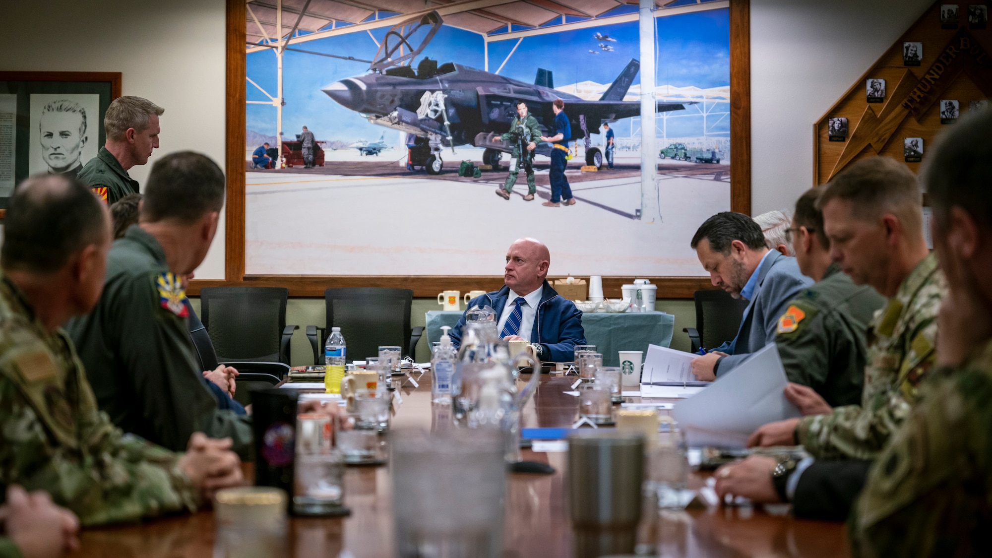 U.S. Senator Mark Kelly (center) listens to a briefing in the 56th Fighter Wing conference room, March 10, 2023, at Luke Air Force Base, Arizona.