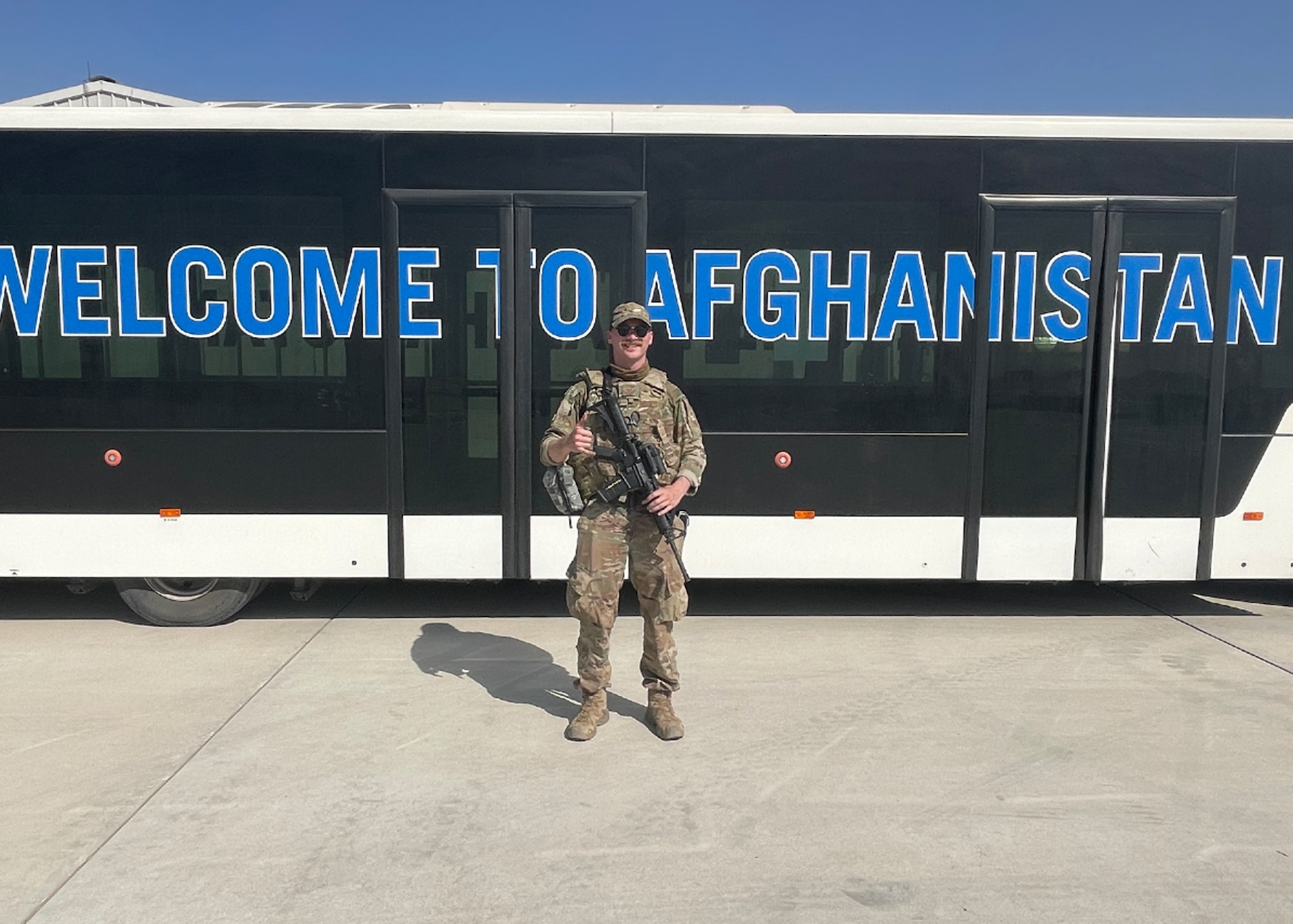 Staff Sgt. Harold Balcom, 75th Operations Support Squadron, poses in front of an abandoned airport shuttle at Hamid Karazai International Airport