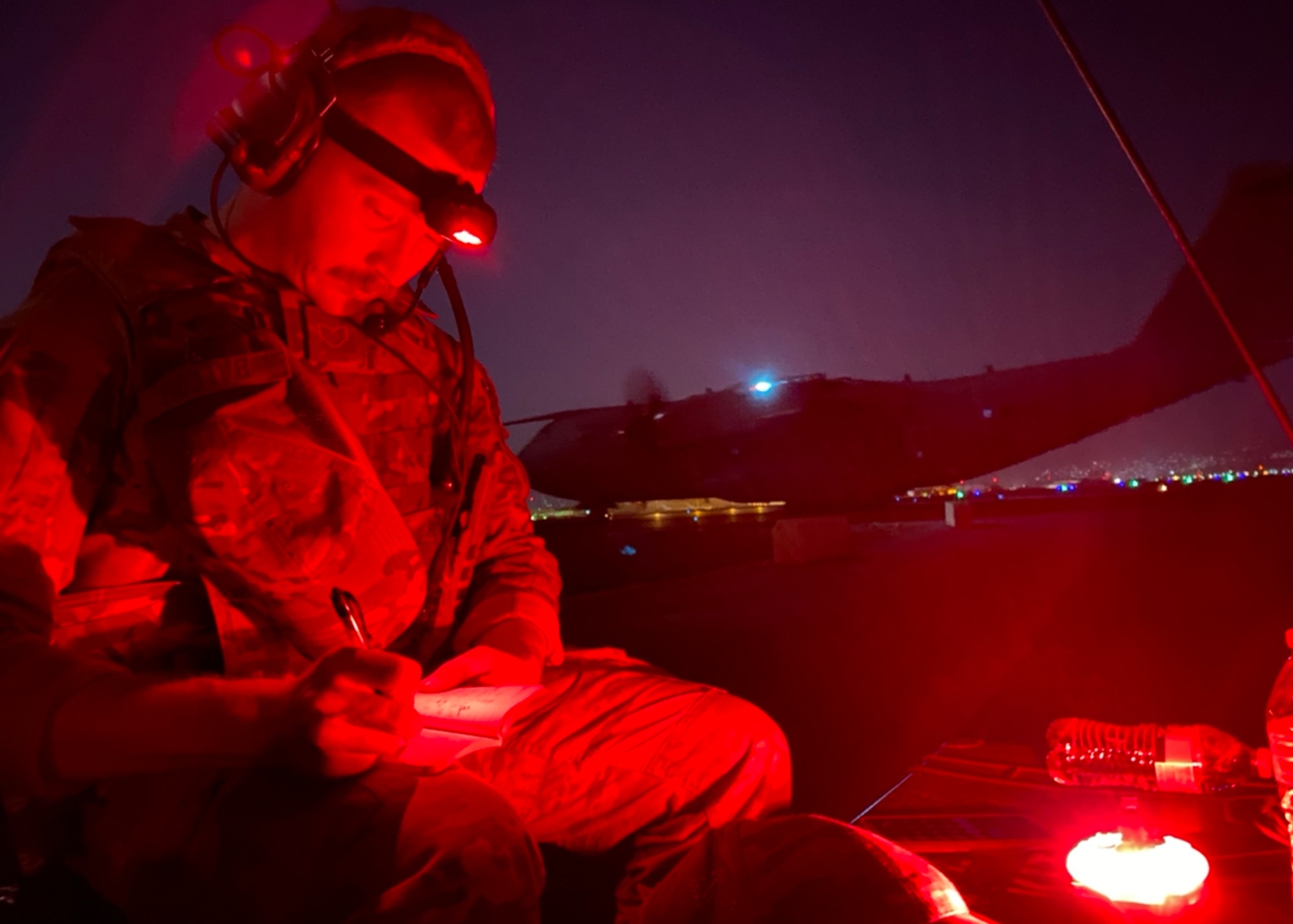 Staff Sgt. Harold Balcom, 75th Operations Support Squadron, performs night operations while an Airbus A400 taxis out with civilians and cargo to evacuate out of Kabul, Afghanistan.