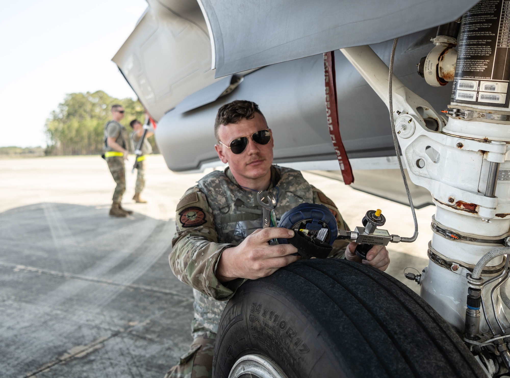 A photo of an F-35 maintainer performing an inspection