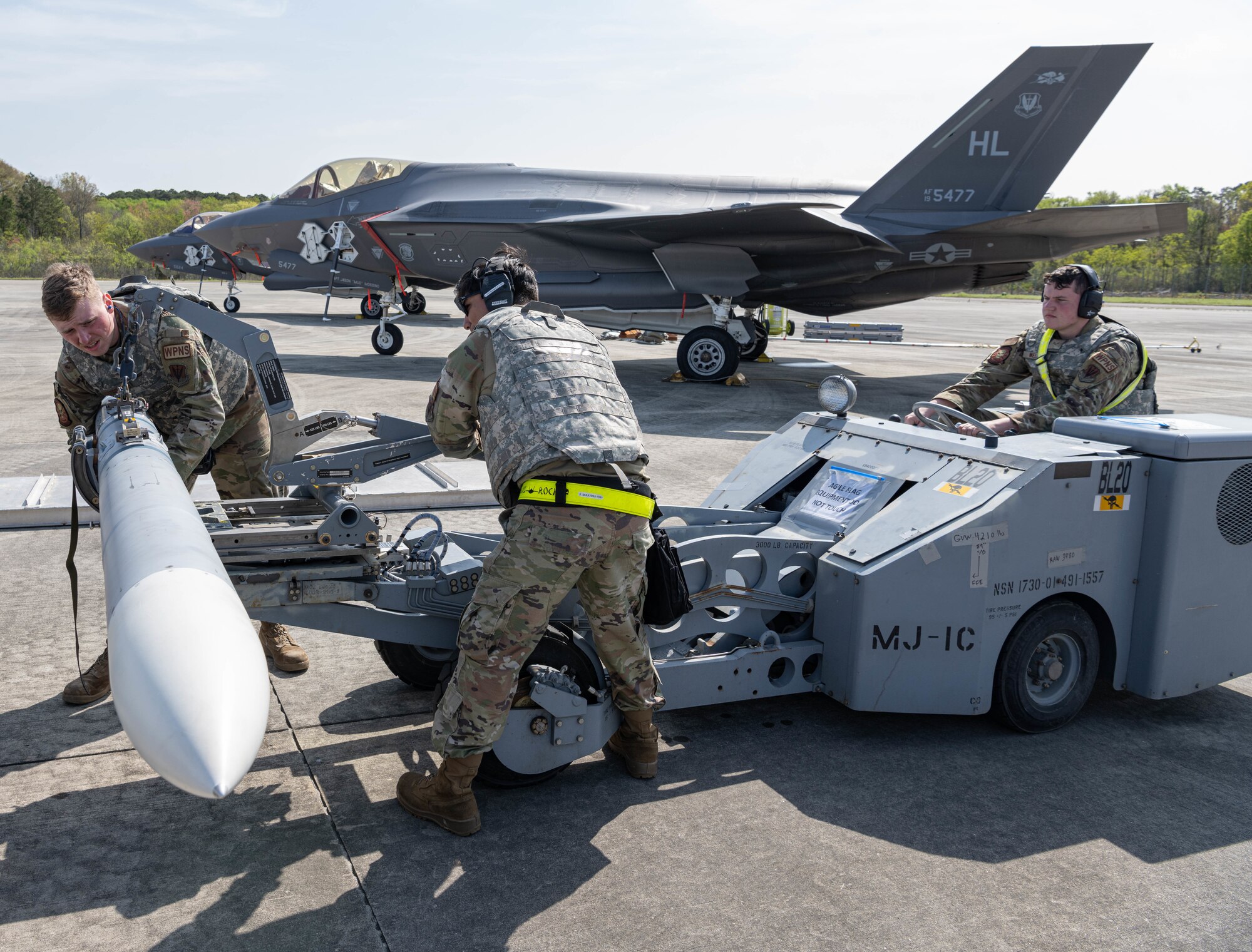 a photo of weapons loaders preparing a missile