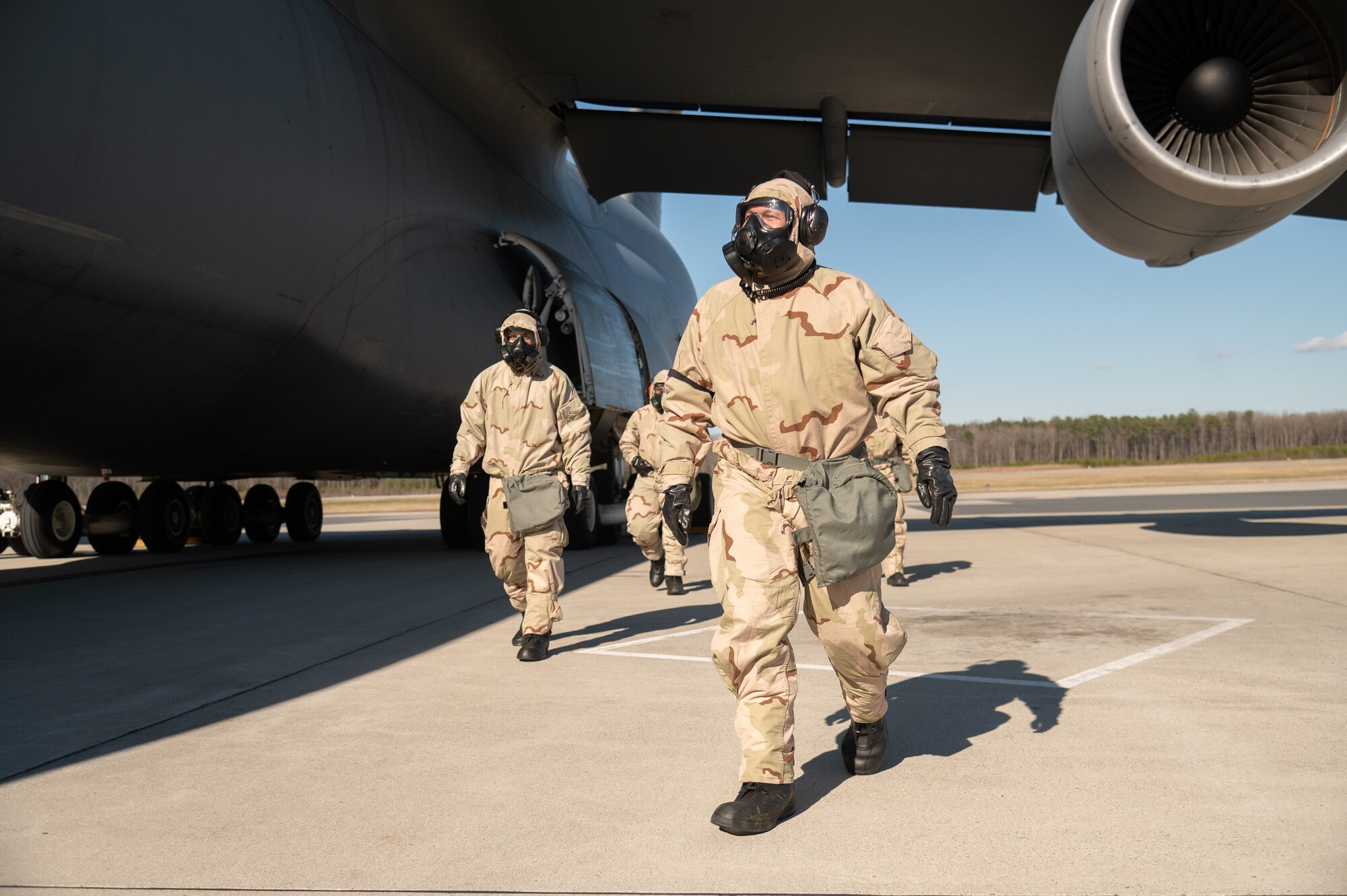 Airmen with the 512th Aircraft Maintenance Squadron prepare to board a C-5M Super Galaxy while wearing mission oriented protective posture gear during a readiness exercise at Dover Air Force Base, Delaware, March 8, 2023. The exercise tested the abilities of Dover AFB Airmen to generate, employ and sustain airpower across the world in a contested and degraded operational environment. (U.S. Air Force photo by Mauricio Campino)