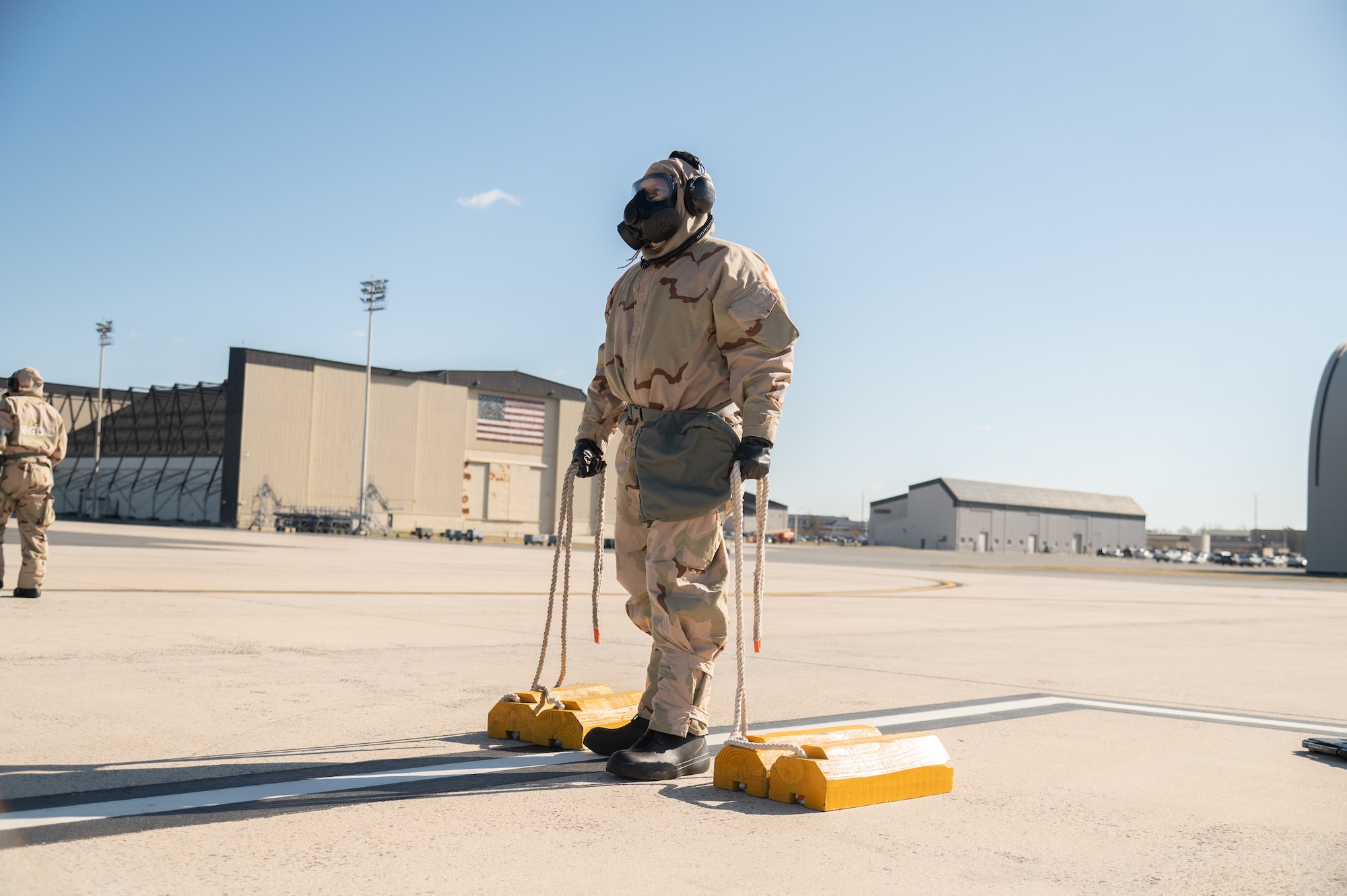 An Airman with the 512th Aircraft Maintenance Squadron prepares to chock a C-5M Super Galaxy while wearing mission oriented protective posture gear during a readiness exercise at Dover Air Force Base, Delaware, March 8, 2023. The exercise tested the abilities of Dover AFB Airmen to generate, employ and sustain airpower across the world in a contested and degraded operational environment. (U.S. Air Force photo by Mauricio Campino)