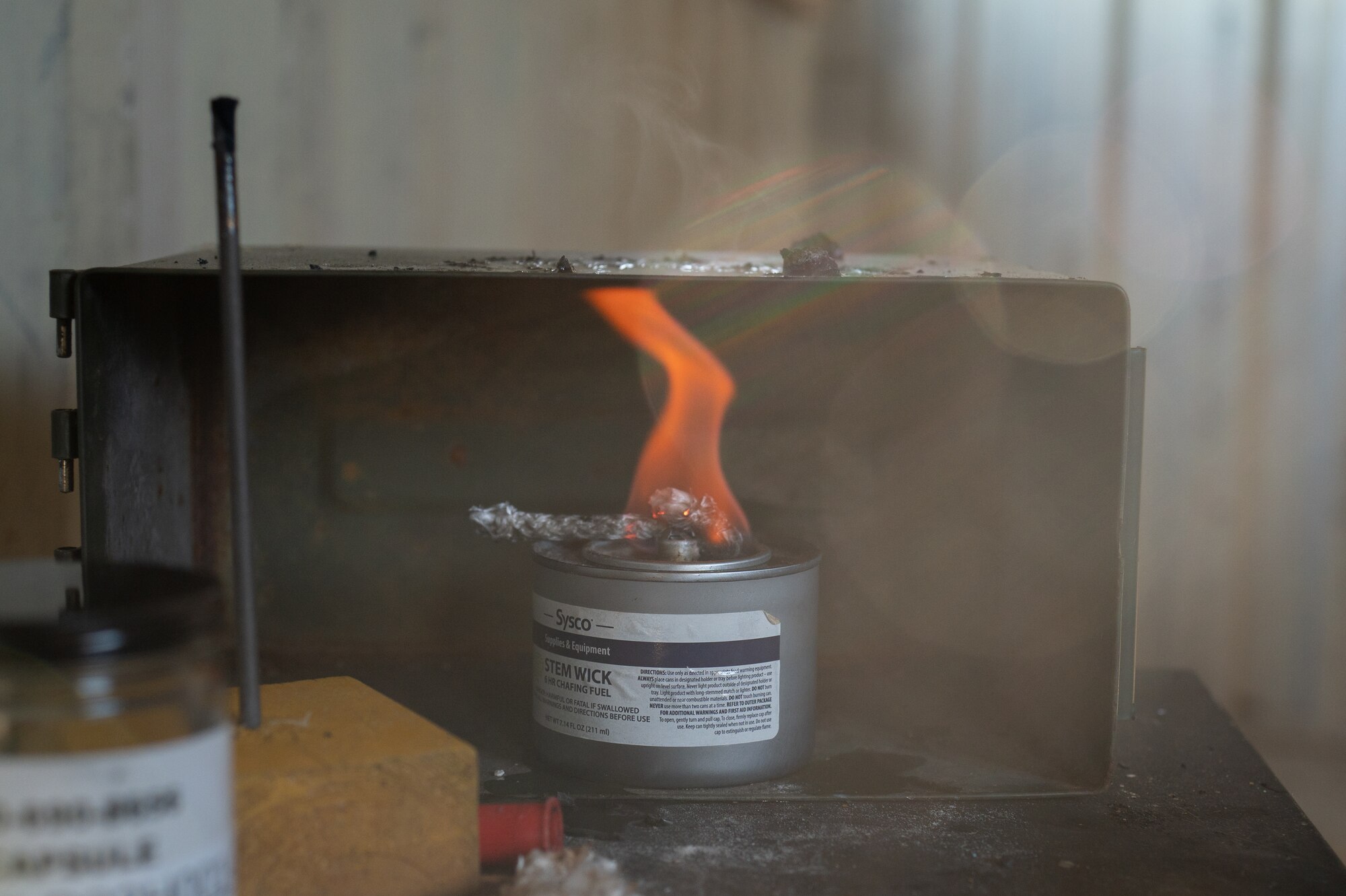 Tear gas tablets burn during a chemical, biological, radiological, and nuclear defense training during a readiness exercise at Dover Air Force Base, Delaware, March 7, 2023. The exercise tested the abilities of the 436th Airlift Wing to generate, employ and sustain airpower across the world in a contested and degraded operational environment. (U.S. Air Force photo by Mauricio Campino)
