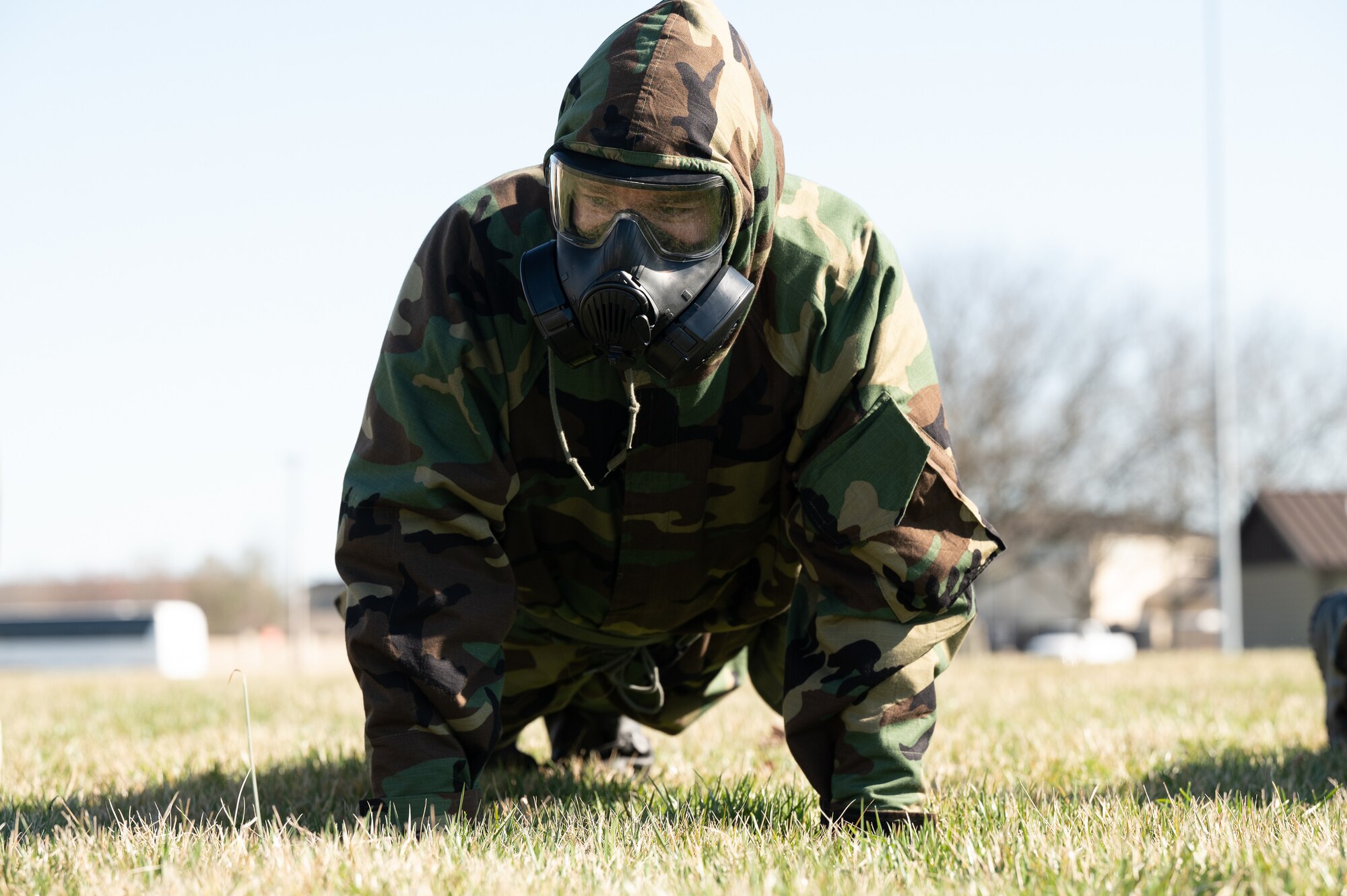An Airman with the 436th Civil Engineer Squadron performs push-ups in mission oriented protective posture gear during a readiness exercise at Dover Air Force Base, Delaware, March 7, 2023. The Airmen practiced MOPP gear donning drills and performed exercises if they donned the gear incorrectly. (U.S. Air Force photo by Mauricio Campino)