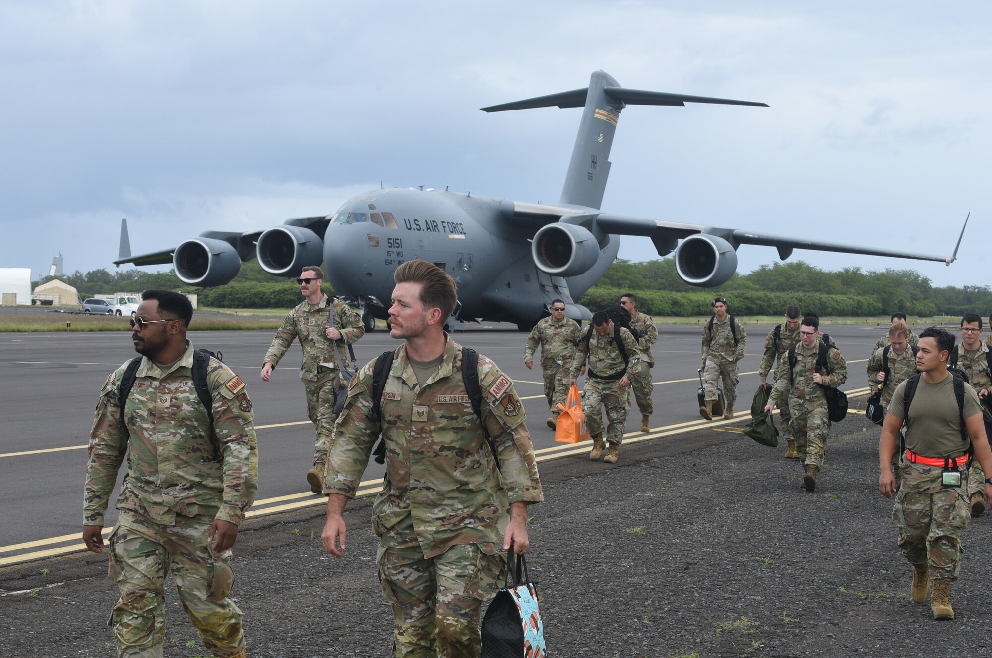 Total Force Airmen from the 154th and 15th Aircraft Maintenance Groups arrive at the Pacific Missile Range Facility at Barking Sands, Hawaii, March 7, 2023. Aircraft armament systems crews flew to Kauai on a C-17 Globemaster III to help receive, rearm and launch fighter aircraft within a condensed time window.