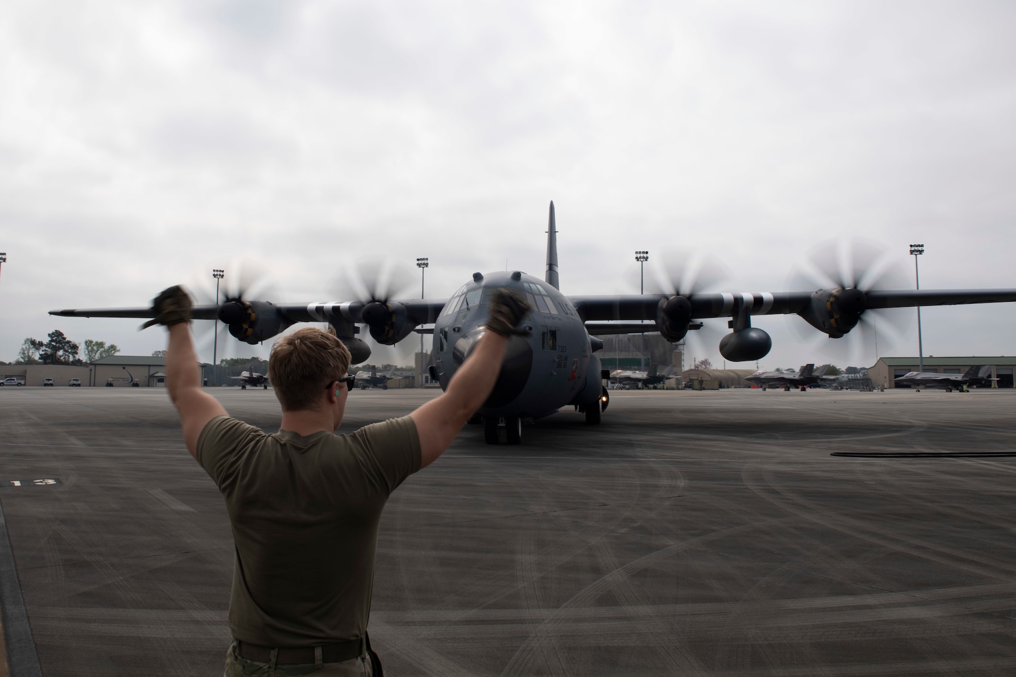 Staff Sgt. Brenden Swartz, 120th Airlift Squadron crew chief, directs a C-130H Hercules during Agile Flag 23-1, after landing at the Air Dominance Center, a combat readiness training center, in Savannah, Ga., March 1, 2023. During the exercise, the 120th AS supported agile combat employment concepts which require forces to rapidly insert into theaters, establish logistics and communications with theater command and control, receive follow-on forces, generate the mission, and project combat power across all domains, while making the critical decisions needed to remain agile. (U.S. Air Force photo by Tech. Sgt. Joshua Edwards)