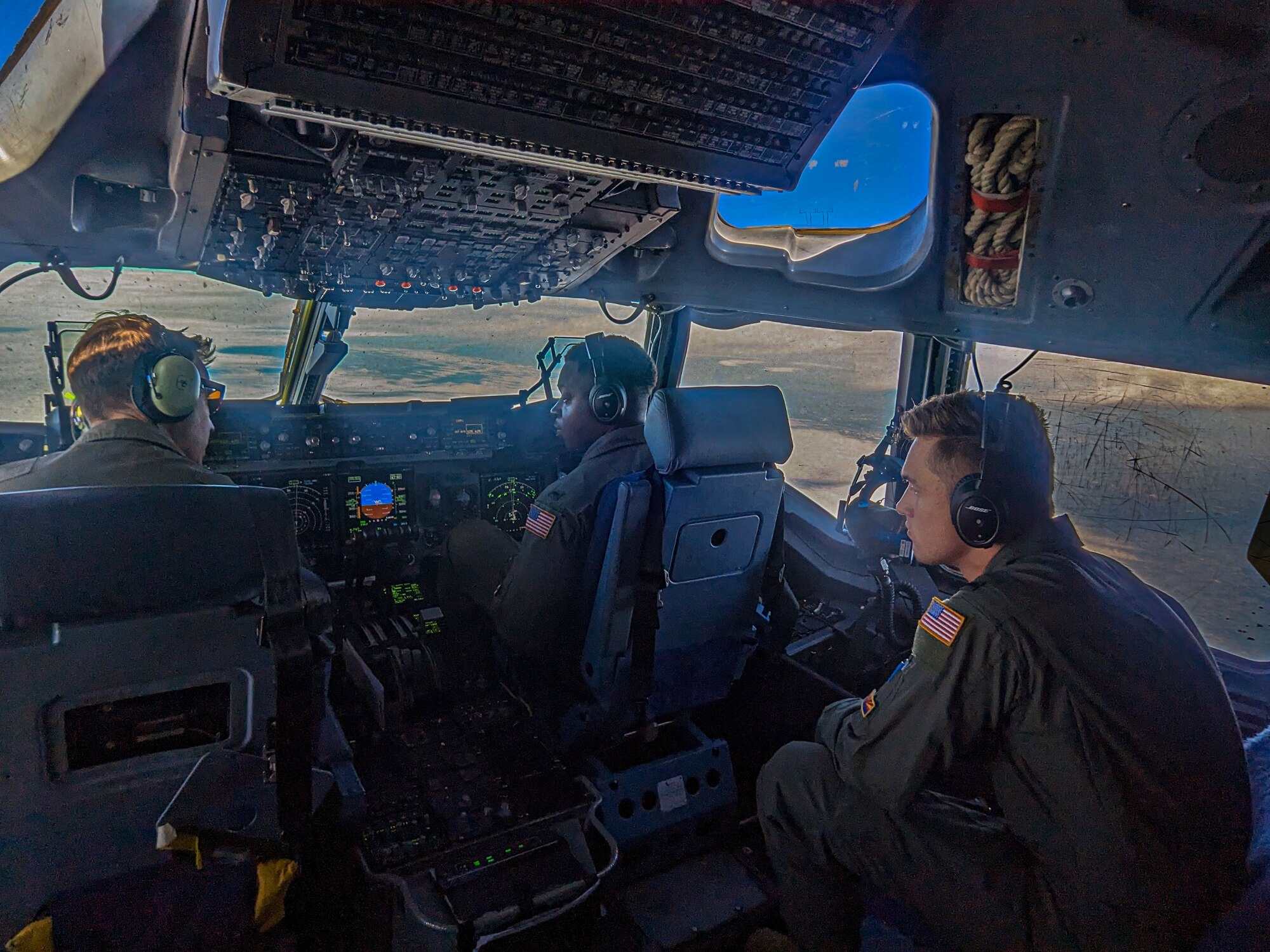 Air Force Reserve 701st Airlift Squadron C-17 Globemaster III pilots, 1st Lt. John Waller and 1st Lt. Dylan Carroll, look to Maj. James Witherspoon for instruction during an in-flight training mission, March 9, 2023. The aircrew from Joint Base Charleston refueled in-flight from the Kansas Air National Guard's 117th Air Refueling Squadron while flying westward over the Great Plains and the Rocky Mountains. (U.S. Air Force photo by Tech. Sgt. Della Creech)