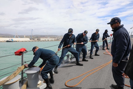 Boatswain’s mate 1st Class Luke Swire, right,  assigned to the Arleigh Burke-class guided-missile destroyer USS Delbert D. Black (DDG 119), supervises as  Sailors moore the ship to the pier in Civitavecchia, Italy during a scheduled port visit, Mar. 11, 2023. The George H.W. Bush Carrier Strike Group is on a scheduled deployment in the U.S. Naval Forces Europe area of operations, employed by U.S. Sixth Fleet to defend U.S., allied, and partner interests.