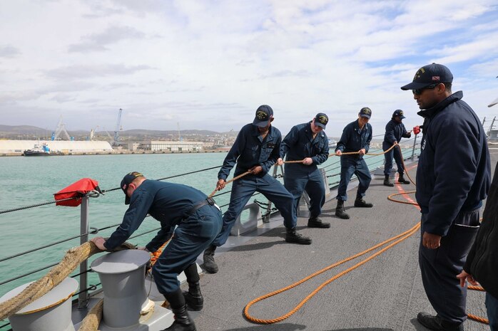 Boatswain’s mate 1st Class Luke Swire, right,  assigned to the Arleigh Burke-class guided-missile destroyer USS Delbert D. Black (DDG 119), supervises as  Sailors moore the ship to the pier in Civitavecchia, Italy during a scheduled port visit, Mar. 11, 2023. The George H.W. Bush Carrier Strike Group is on a scheduled deployment in the U.S. Naval Forces Europe area of operations, employed by U.S. Sixth Fleet to defend U.S., allied, and partner interests.