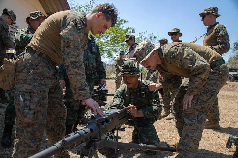 .S. Marine Corps Cpl. Alexander Reynaga, left, and Lance Cpl. Derek Yonan, both machine gunners with Echo Company, Battalion Landing Team 2/4, 13th Marine Expeditionary Unit, show the M2 .50-caliber heavy machine gun to a Royal Thai Marine during Exercise Cobra Gold in Chantaburi province, Kingdom of Thailand, Feb. 28, 2023.